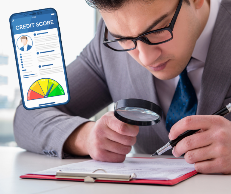 A man in glasses using a magnifying glass to closely review a paper document, with a credit score app shown on a phone beside him.
